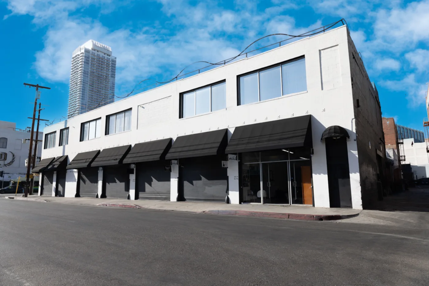 Storefronts along S Los Angeles Street with the Downtown LA skyline